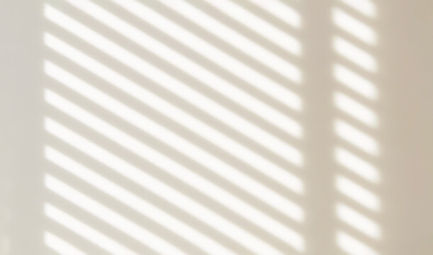 The light from the window blinds on the wall, the shadow lines from the curtain, blurry shadows and silhouettes.. Mockup, copy space for tex