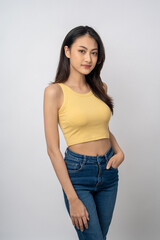 Beautiful smiling happy young asian woman in yellow shirt. Charming female lady standing pose on isolated white background. Asian woman people looking camera confident with backdrop.