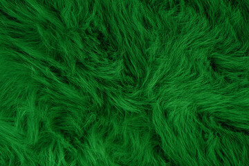 Fototapeta premium Luxurious vibrant emerald green fluffy faux fur fabric background with long soft fibers texture