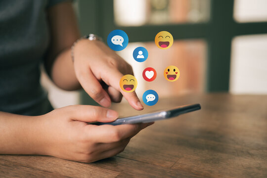 A woman is playing on her mobile phone. The concept of social media includes chatting with friends online and sending reaction icons through the application.