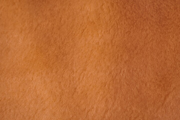 Detailed close up view of warm orange brown soft felt fabric material surface texture background