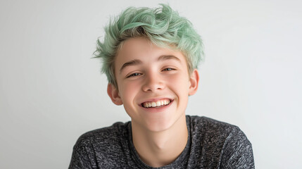 Smiling young boy with green dyed hair looking cheerfully into camera. Portrait of cheerful caucasian child with unusual hairstyle.