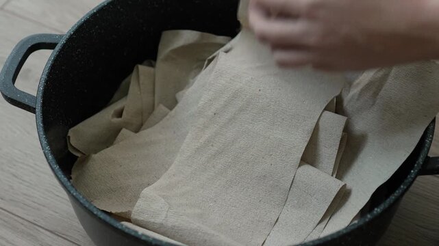 woman folds toilet paper into a pot to create papier mache material. woman doing crafts. DIY decorations. hobby, recreation, crafts, do it yourself, leisure