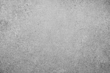 Rough gray speckled concrete surface textured background showing many small dark particles evenly...