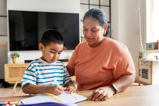 Mother helping her son with drawing at home