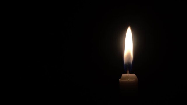 a video showing the light from a candle being lit as lighting due to the pitch black conditions caused by a power outage in the neighborhood at night

