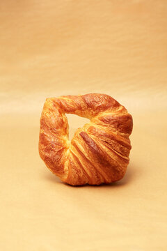 Freshly baked artisanal croissant on a wooden surface