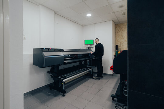 Worker in automotive shop using advanced printing technology