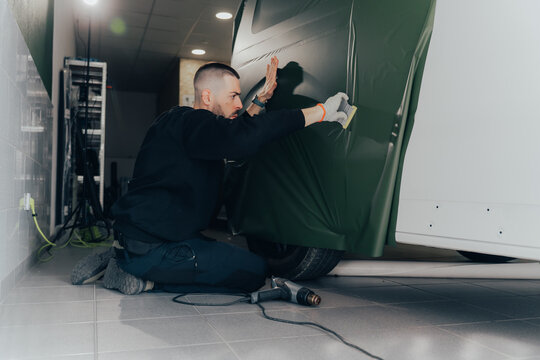 Vehicle wrapping in progress at an automotive workshop