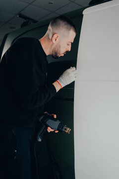 Skilled worker in vehicle customization with vinyl wrap