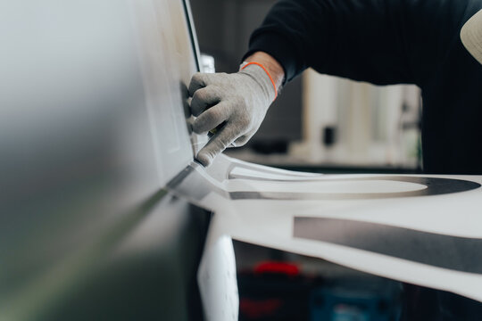 Skilled artisan applies vehicle branding detail