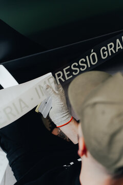 Skilled worker applies vinyl wrapping for vehicle customization