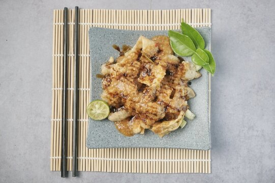 Batagor or baso Tahu Goreng. Indonesian Traditional Street Food Fried Dumpling Made from Fish with Tapioca Flour, Tofu, and Dumpling Wrapper. Served with Spicy Peanut Sauce, Sweet Soy Sauce, and Lime 