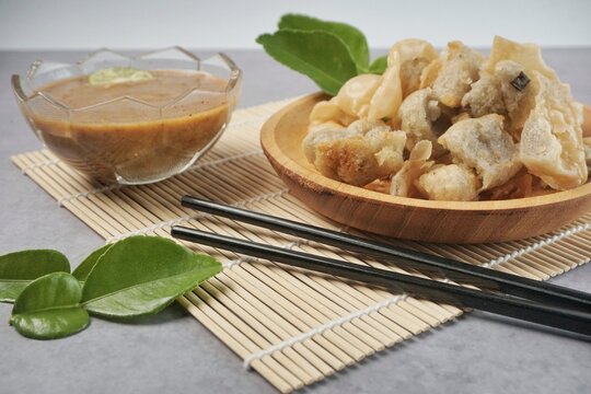 Batagor or baso Tahu Goreng. Indonesian Traditional Street Food Fried Dumpling Made from Fish with Tapioca Flour, Tofu, and Dumpling Wrapper. Served with Spicy Peanut Sauce, Sweet Soy Sauce, and Lime 
