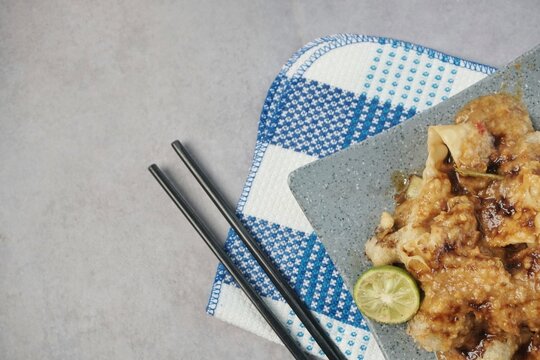 Batagor or baso Tahu Goreng. Indonesian Traditional Street Food Fried Dumpling Made from Fish with Tapioca Flour, Tofu, and Dumpling Wrapper. Served with Spicy Peanut Sauce, Sweet Soy Sauce, and Lime 