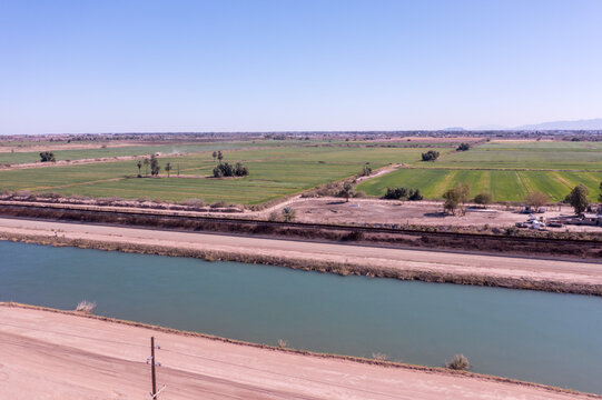 Imperial Valley Irrigation Canal and Mexico Farmland Across Border Wall