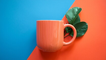 vibrant coral coffee mug on bold blue and orange background with green leaves decor