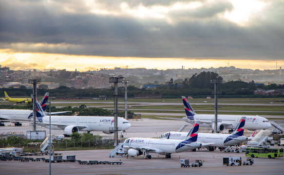 Widebody and narrowbody LATAM commercial aircraft parked on apron near Terminal 3 at S&atilde;o Paulo/Guarulhos International Airport after sunrise - S&atilde;o Paulo, Brazil