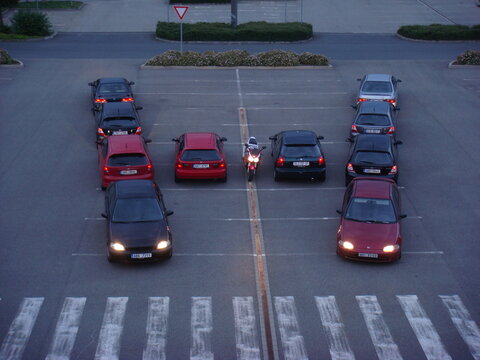 High angle view of Honda cars and motorcycle arranged in letter H shape. Japanese car enthusiasts meeting in parking lot at dusk.