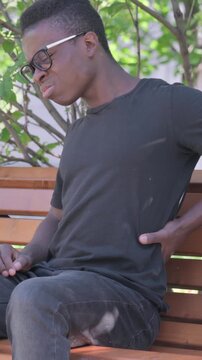 Young African Man Sitting Outdoor with Back Pain, Vertical Video