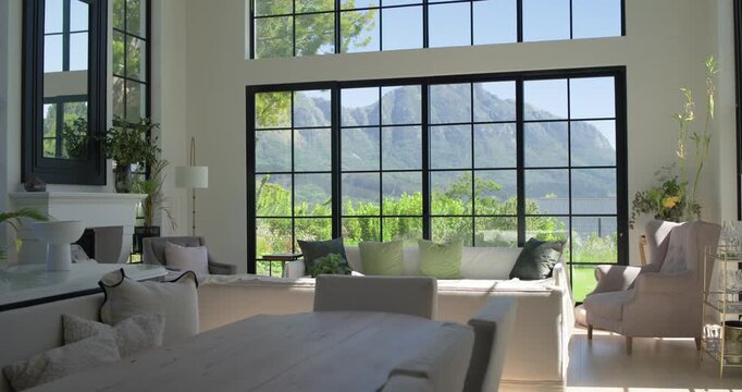 Camera is slowly shifting left and forward, revealing window view, fireplace and sunlit sofa