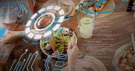 Sharing large salad bowl, team in casual clothes reaching across cafe table with AR HUD, lemonade