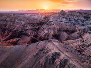 Golden sunset over geological layered sedimentary rock formation in Altyn Emel national park