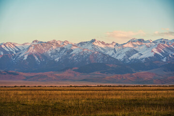 Snowcapped mountain range with grassland in the evening at Kyrgyzstan © Mumemories
