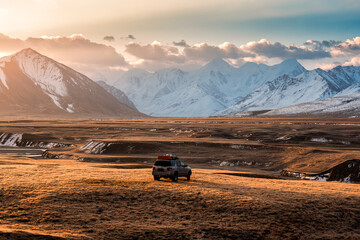 Naklejka premium Adventure vehicle car parked on remote wilderness and mountain valley during the morning at Sary Jaz valley