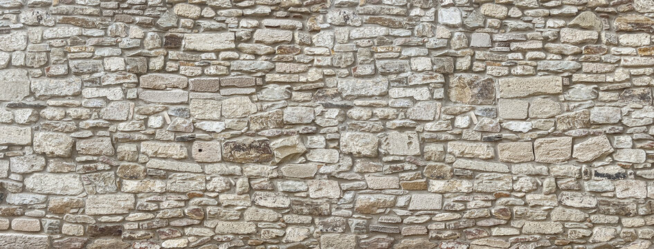 Old stone wall texture background presenting rough masonry pattern