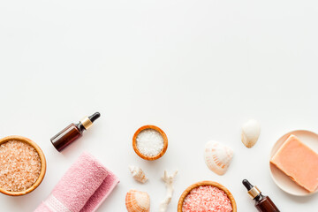 Essential oil and spa cosmetic products with sea shells, top view. Beauty spa therapy cosmetics and wellness background