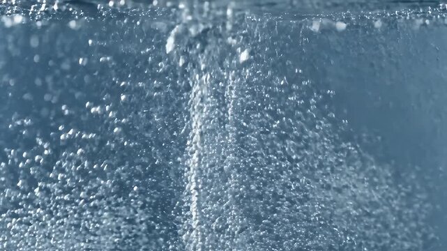 Close-up view of cascading water droplets creating a foamy, bubbly texture underwater