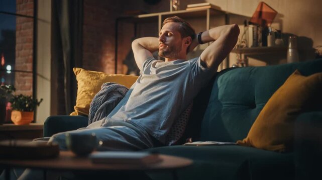 A cinematic shot features a man relaxing on a comfortable green velvet couch in a warm, inviting living room with soft lighting, creating a sense of calm and tranquility.