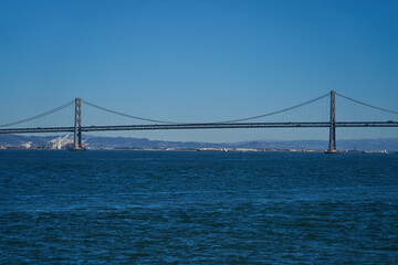 Obraz premium San Francisco, USA - October 28, 2025 - Iconic Bay Bridge spans across the deep blue water under a clear sky