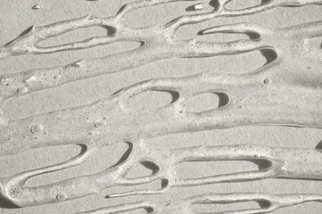 Viscous transparent gel flowing on smooth surface, creating an abstract pattern