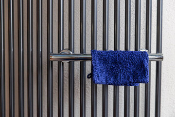 Ein blauer Waschlappen h&auml;ngt &uuml;ber einem Chrom Handtuchhalter
