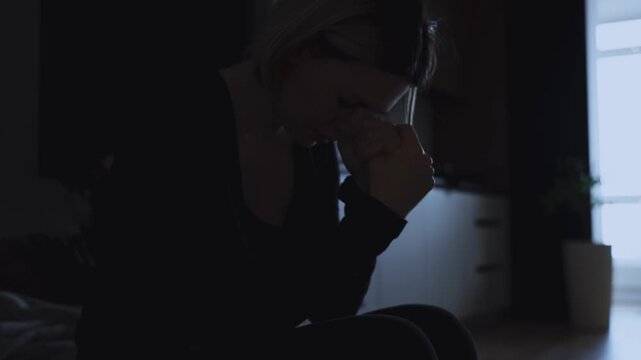 Black silhouette upset unhappy woman suffers acute anxiety disorder in dark home room. Sad girl lack of money, cry feels bad mood depression emotion. head ache panic attack stress cry, pain hurt woe.