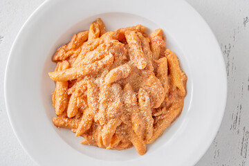 Penne pasta in creamy ricotta tomato sauce with grated parmesan cheese