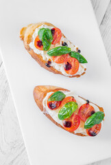 Gourmet bruschetta with stracciatella cherry tomatoes basil and balsamic on bright rustic background