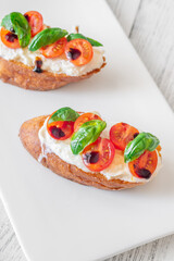 Gourmet bruschetta with stracciatella cherry tomatoes basil and balsamic on bright rustic background