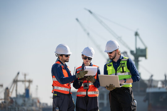 Professional engineering working at shipyard, Professional logistics monitoring cargo operations at industrial shipyard.