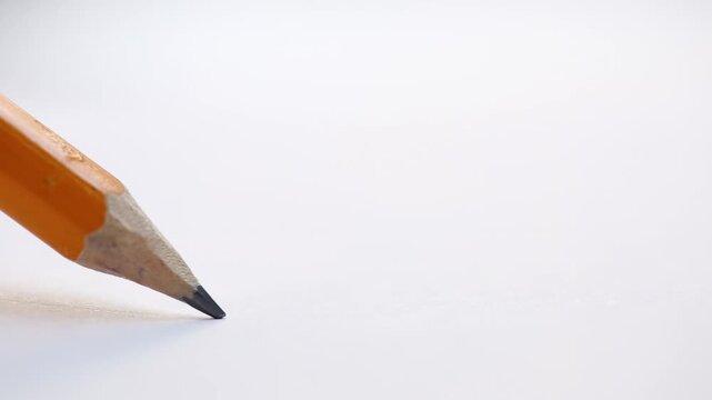 Macro view of a pencil used for drawing on a white sheet of paper