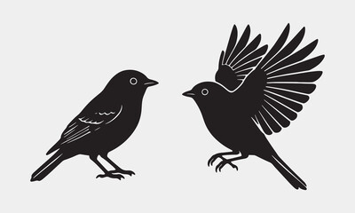 Obraz premium Two elegant black bird silhouettes depicted in a pristine white background, one perched and one in flight, showcasing simplicity and grace