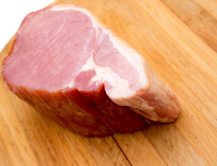 The smoked pork ham on a wooden background.