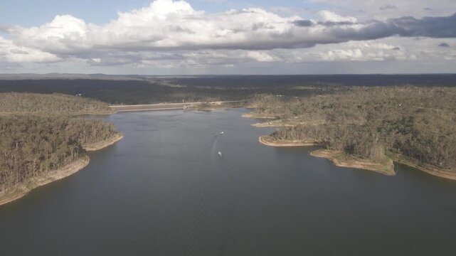 Fly towards aerial of people water skiing Lake Monduran by Fred Haigh dam