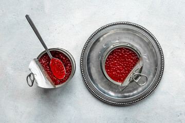 Two jars of red salmon caviar on silver plate. Seafood full of omega-3. Top view