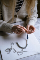 Female hands making handmade beaded jewelry