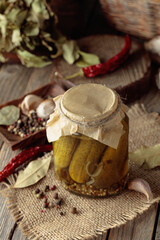 Homemade canned gherkins on a rustic wooden background.