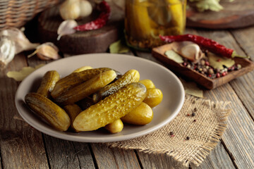 Homemade canned gherkins on a rustic wooden background.