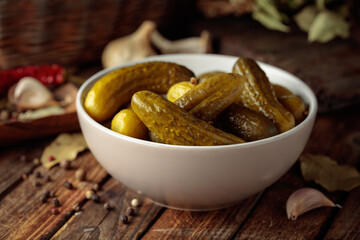 Homemade canned gherkins on a rustic wooden background.